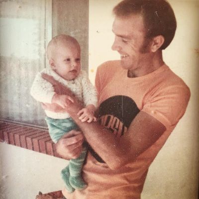 Simmone Jade Mackinnon father, Ian Mackinnon holding Simmone in his hand.